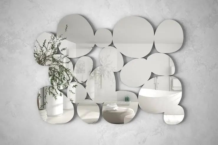 Modern mirror in the shape of pebbles hanging on the wall