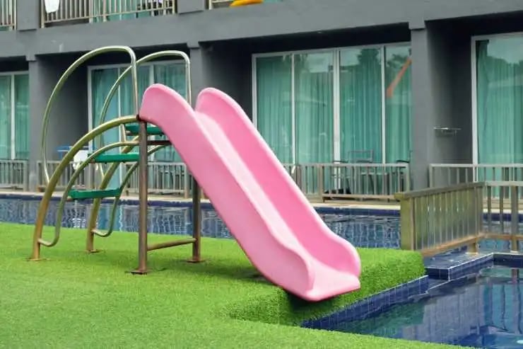 Pink plastic slide for children in the swimming pool